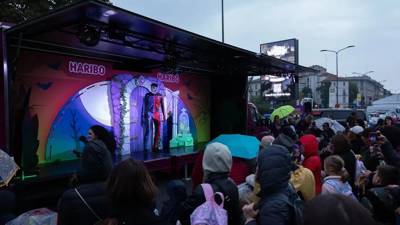 Uno degli spettacoli itineranti Orsetto o Scherzetto HARIBO 2025 in piazza a Milano, con un attore sul palco